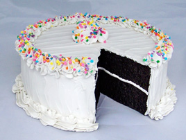 Large Vanilla Frosted Birthday Cake Decorated with Pastel Sprinkles and a Slice Removed