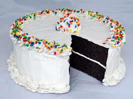 Large Vanilla Frosted Birthday Cake Decorated with Primary Sprinkles and a Slice Removed